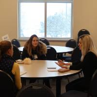 Two students talking with an alumna at the 30 Minute Mentors Event